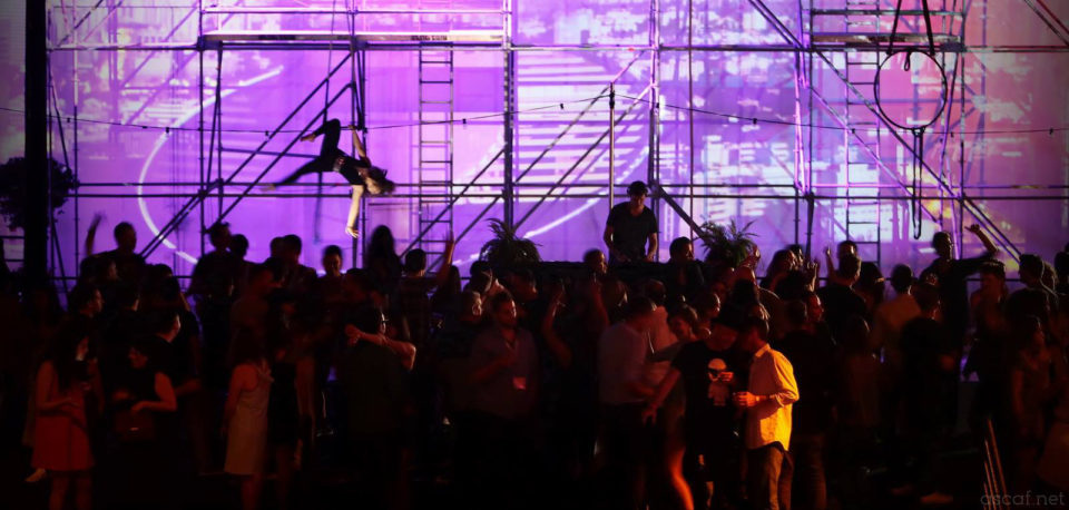 Attendees mingle during an acrobatic performance at the Over The Top Party hosted by Playtika at Casual Connect Tel Aviv 2015.